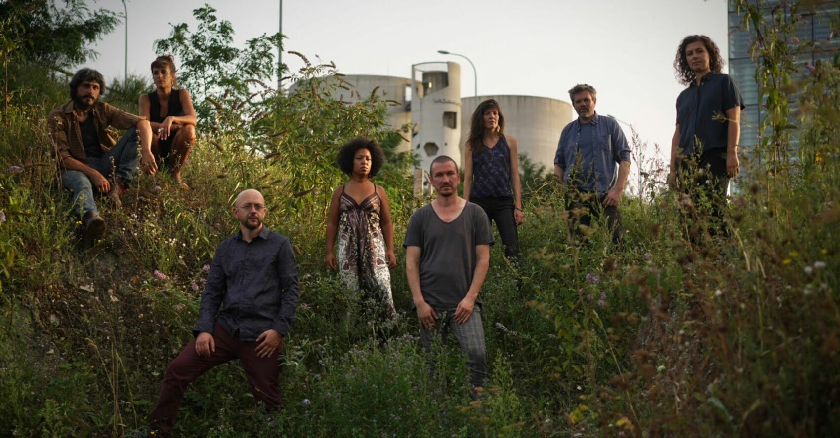 Les huit musiciens et musiciennes du Moger Orchestra qui pose debout dans de l'herbe