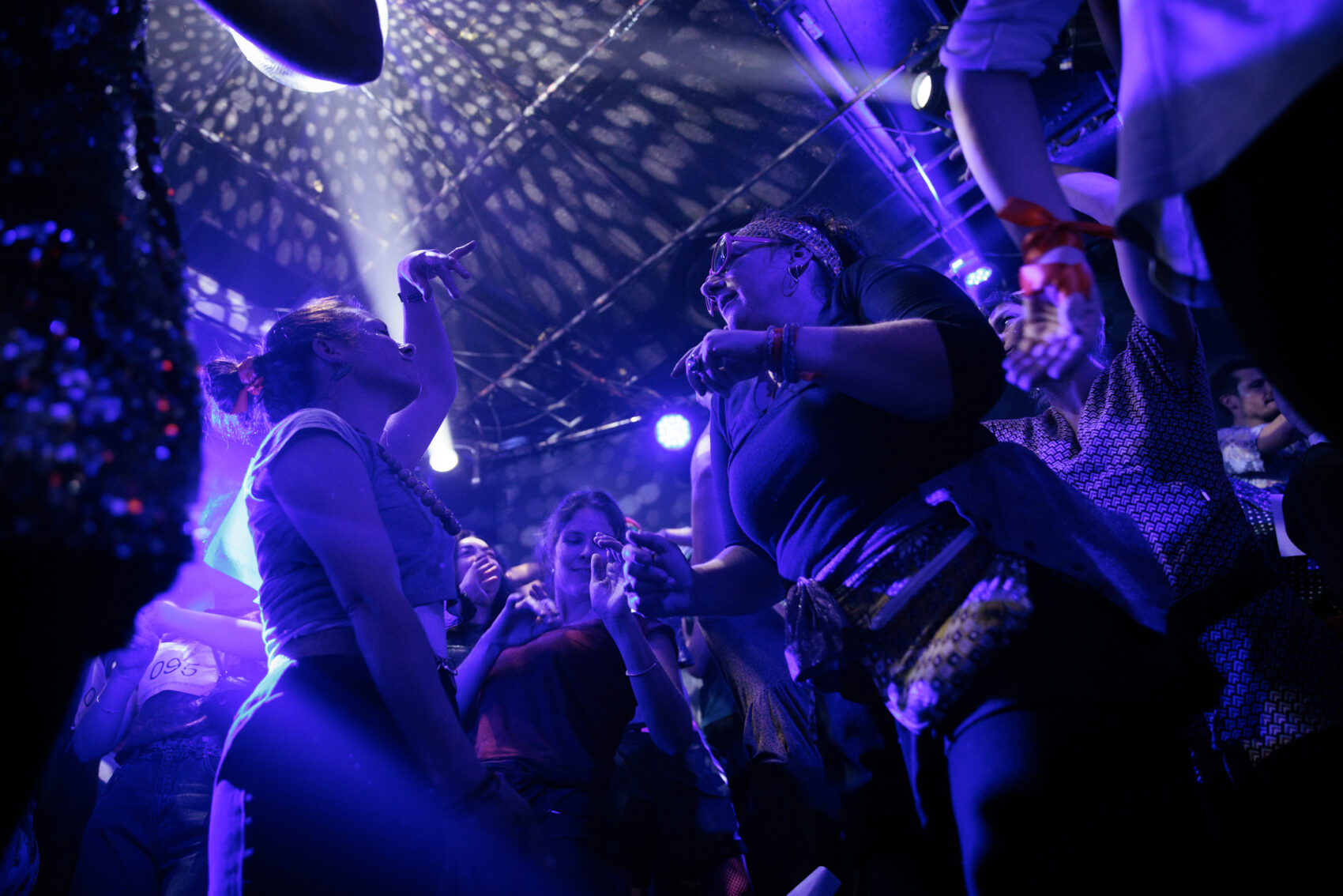 Des gens qui danse dans une ambiance boite de nuit avec des lumières 